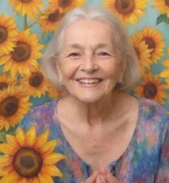 Una anciana sonriente se encuentra con confianza en medio de girasoles vibrantes